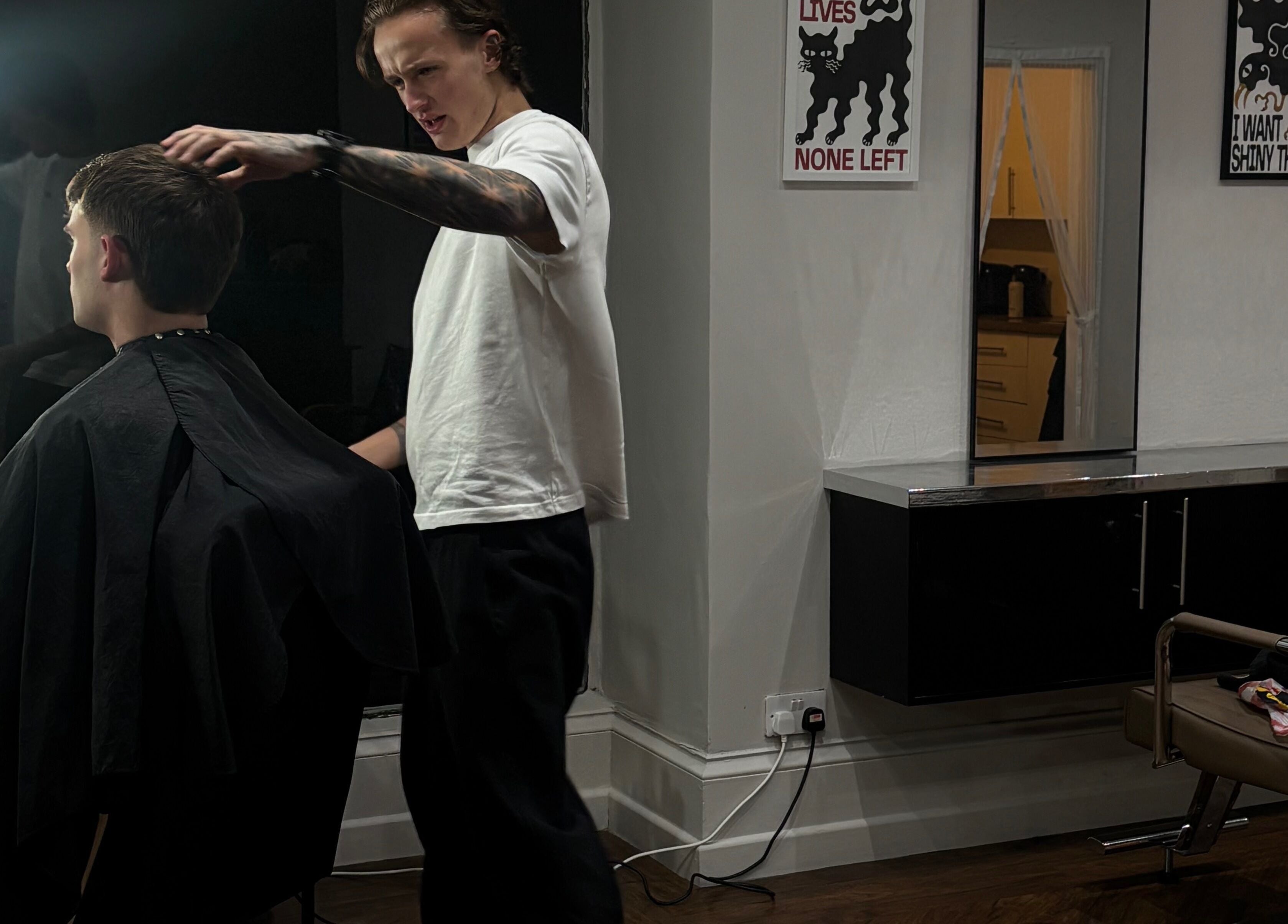 Barber styling a client's hair at H E I G H T S, Dundee, Scotland, GB. Modern interior with chic decor.