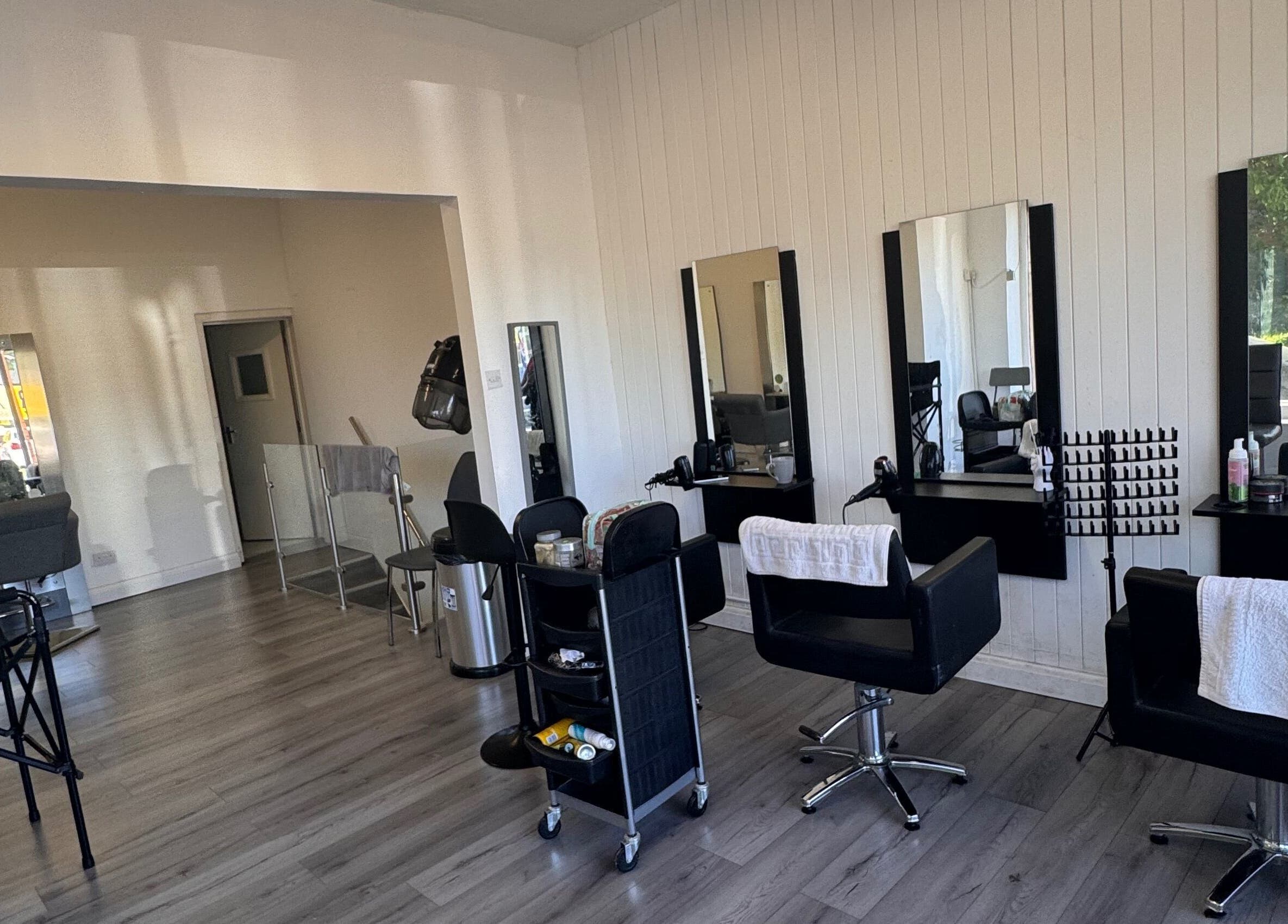 Modern salon interior at TeeBeauty World, Manchester, England, GB featuring sleek styling chairs and mirrors.