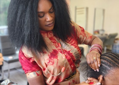 Hairstylist creating intricate braids at TeeBeauty World, Manchester, England, GB.