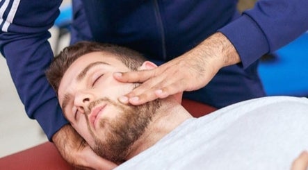 Therapist performs facial massage at Elite Therapy, Luton, England, GB for relaxation and wellness.