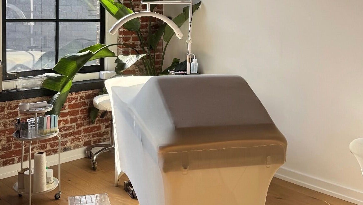 Tranquil treatment room at Cebeauti in Philadelphia, Pennsylvania, US, featuring a massage table and lush greenery.