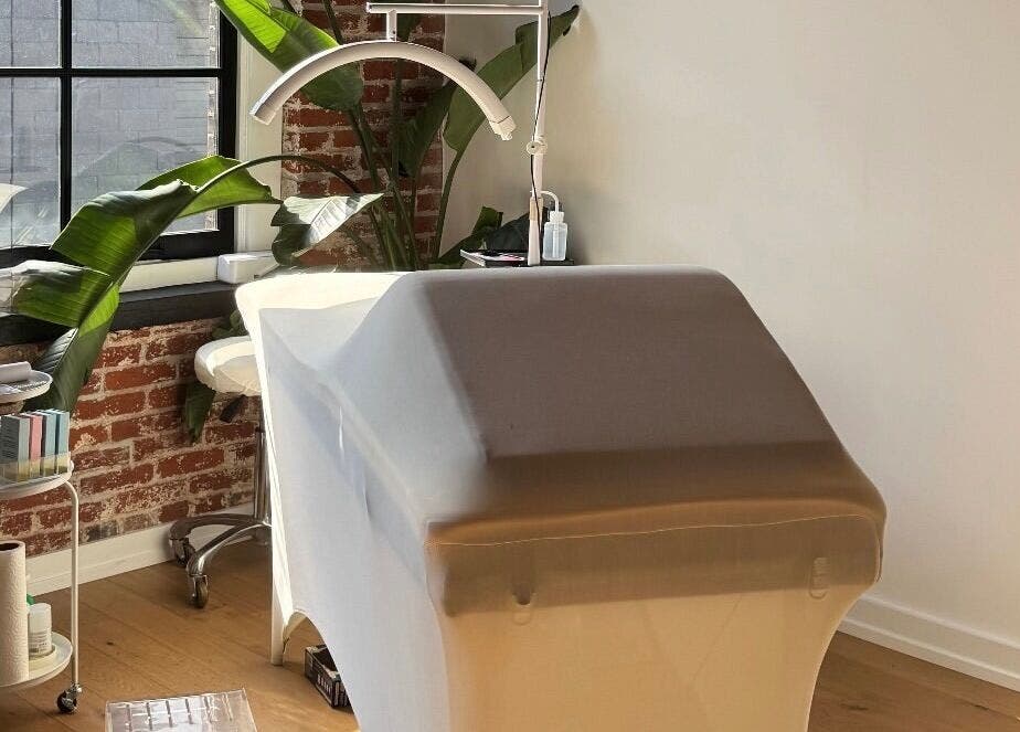 Tranquil treatment room at Cebeauti in Philadelphia, Pennsylvania, US, featuring a massage table and lush greenery.