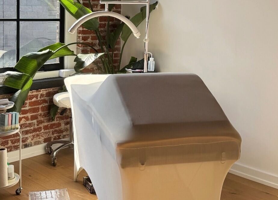 Tranquil treatment room at Cebeauti in Philadelphia, Pennsylvania, US, featuring a massage table and lush greenery.