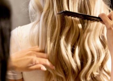 Expert stylist combs wavy blonde hair at Repose Ladies Salon L.L.C, Dubai, Dubai, AE for a flawless finish.