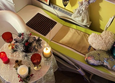 Cozy massage setting at Doctor Massage in London, England, GB with candles and heart-shaped pillows.