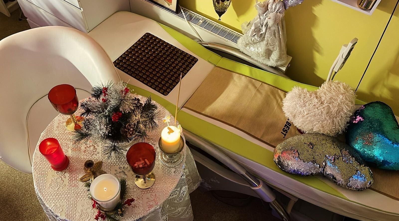 Cozy massage setting at Doctor Massage in London, England, GB with candles and heart-shaped pillows.