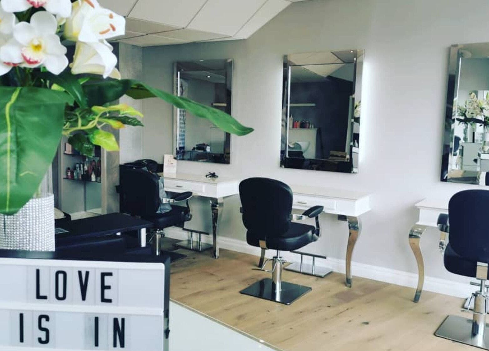 Modern interior of Glow Hair and Beauty Salon, Sutton Coldfield, featuring sleek mirrors and stylish chairs.