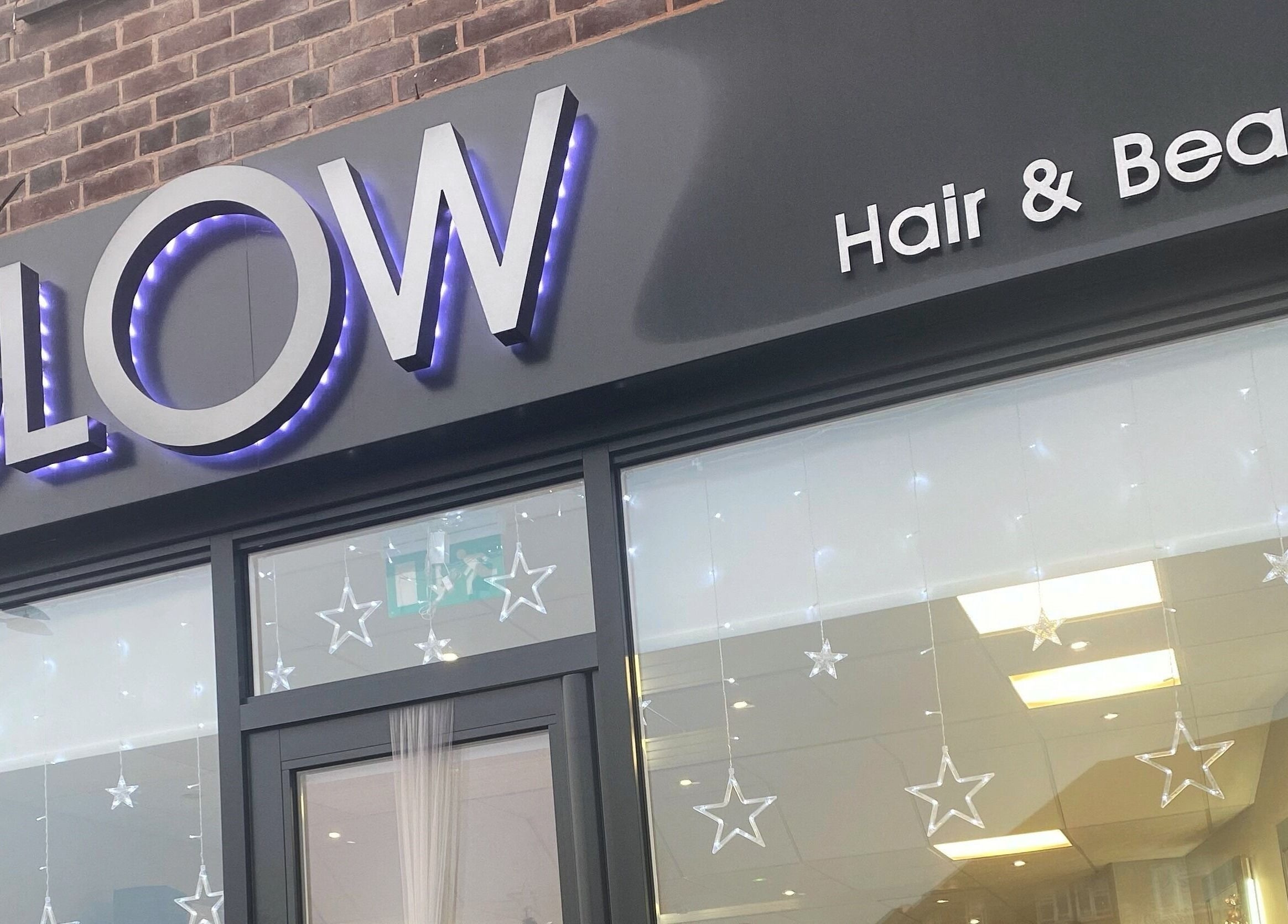 Front view of Glow Hair and Beauty Salon in Sutton Coldfield, England showcasing illuminated signage.