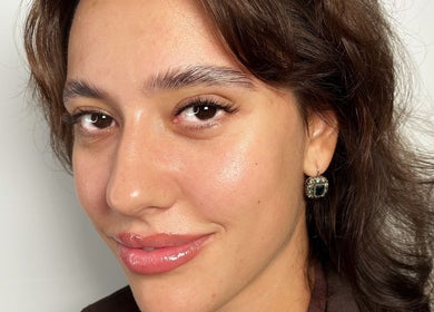 Close-up of woman with glowing skin, styled hair, and earrings at Lolo Beauty | Beauty & Lash Salon London, London, England, GB.