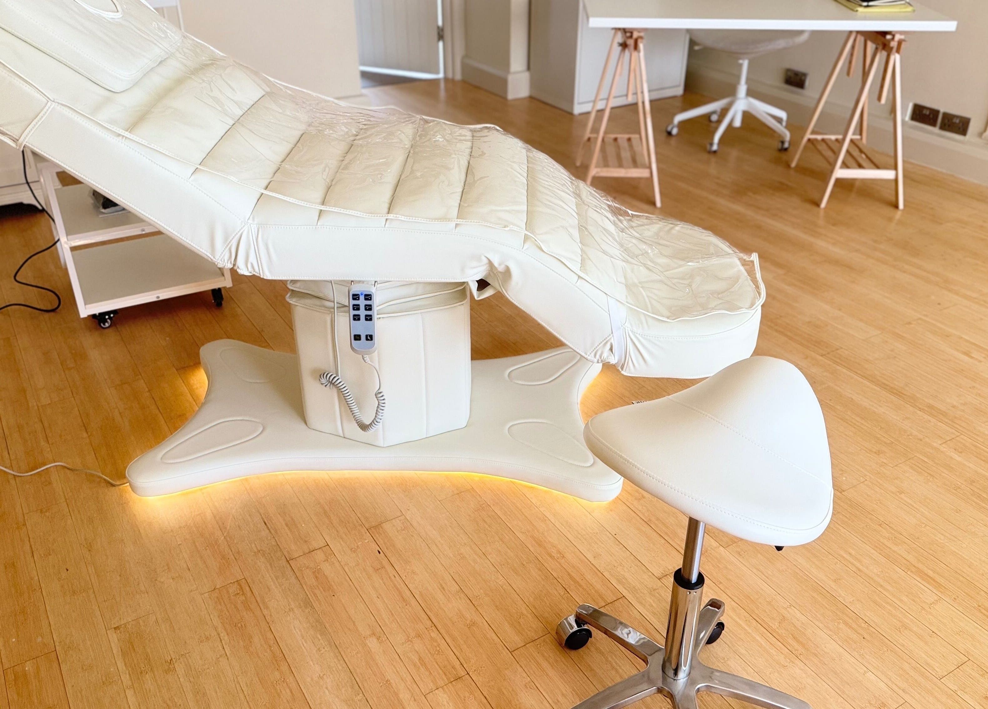 Modern spa treatment room at Brock Aesthetics, Bath, England, GB featuring a plush therapy bed and stool.