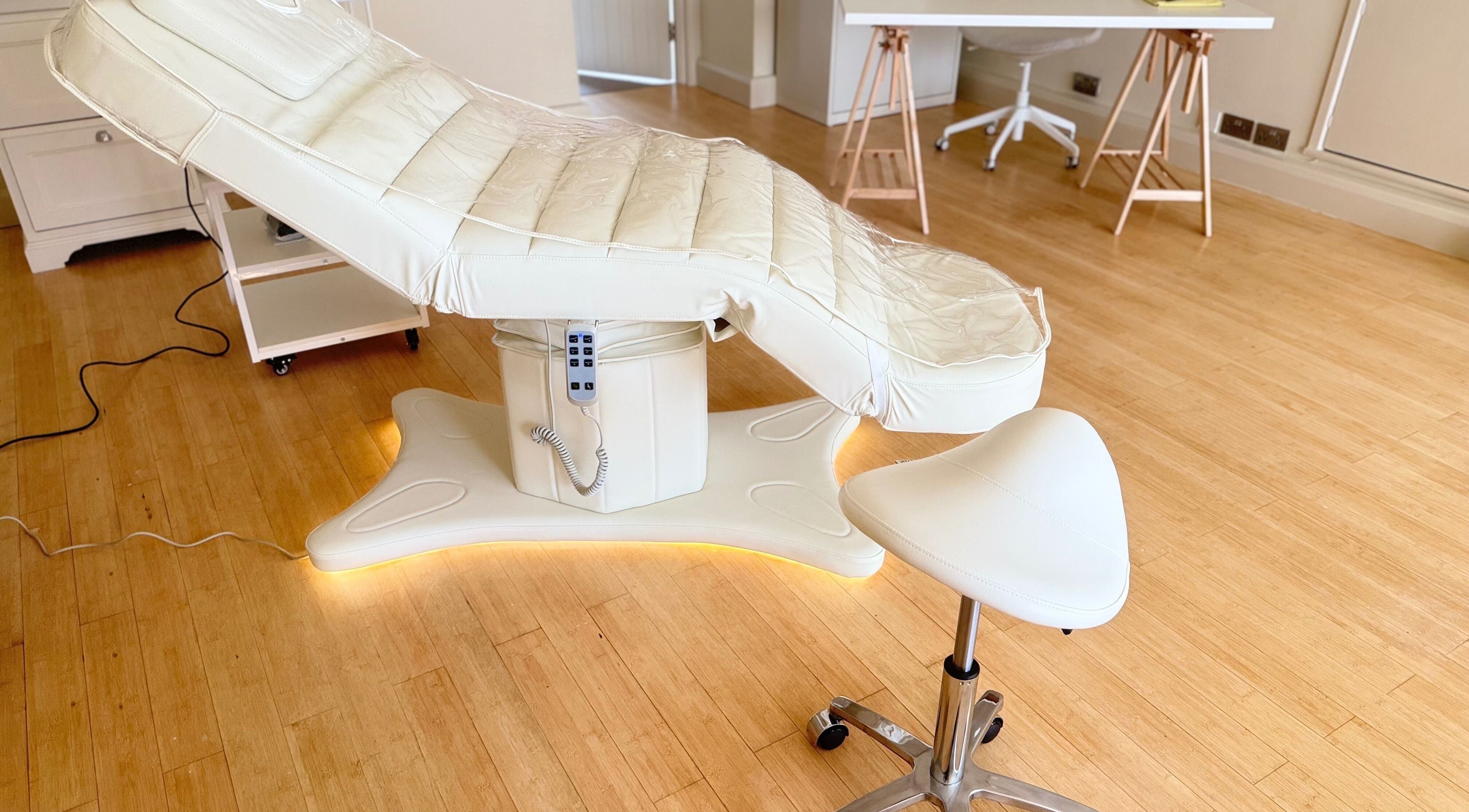 Modern spa treatment room at Brock Aesthetics, Bath, England, GB featuring a plush therapy bed and stool.