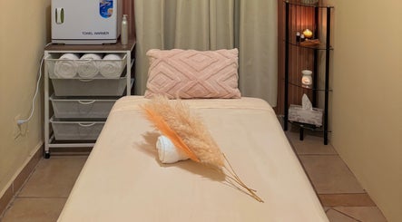 Camilla de masaje relajante en Samer Spa, Puerto Vallarta, Jalisco, MX con toallas y decoración cálida.