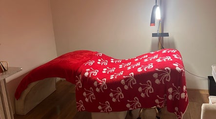 Elegant treatment bed with red floral blanket at The Beauty Bar by Chloe, Kirkcaldy, Scotland, GB.