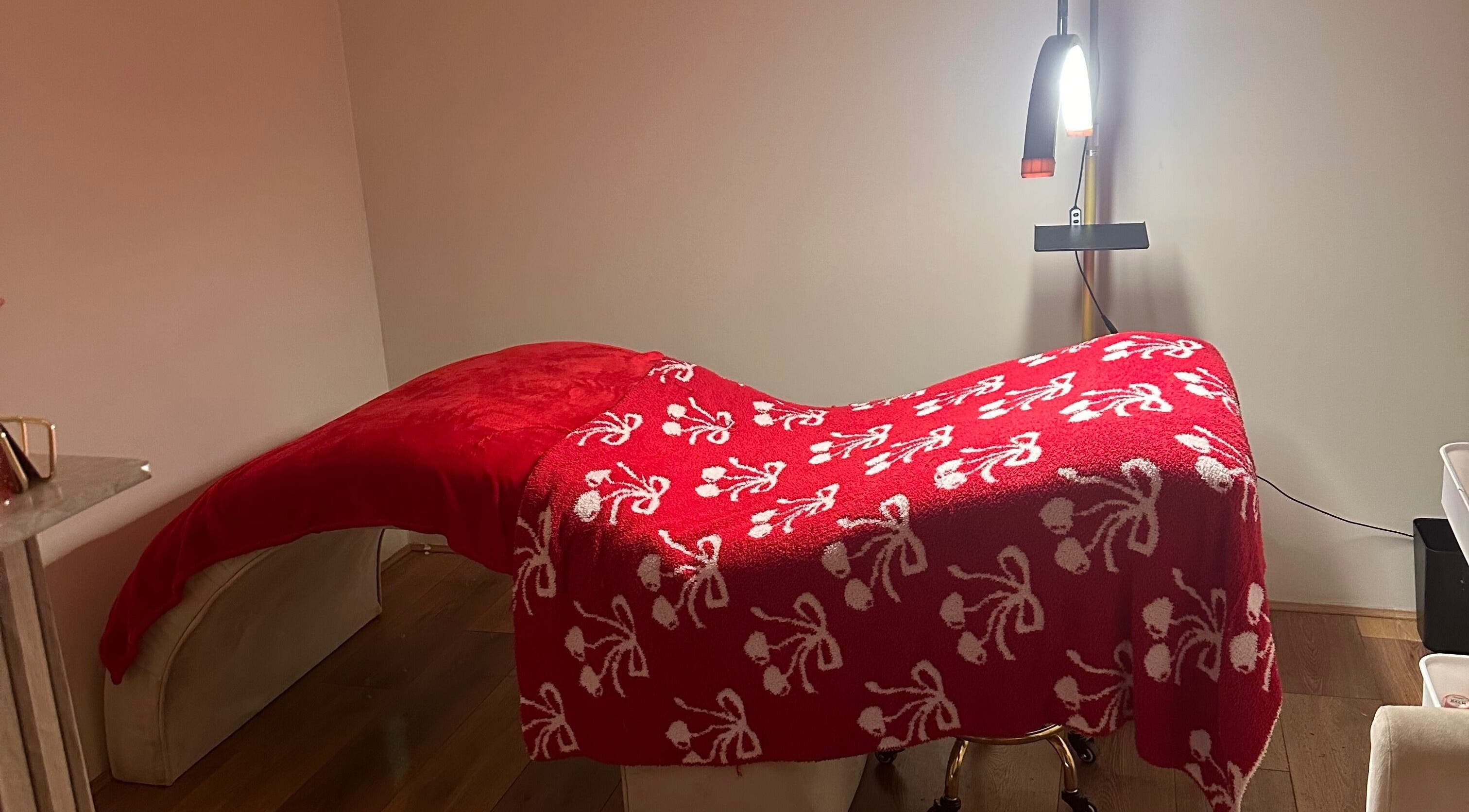 Elegant treatment bed with red floral blanket at The Beauty Bar by Chloe, Kirkcaldy, Scotland, GB.