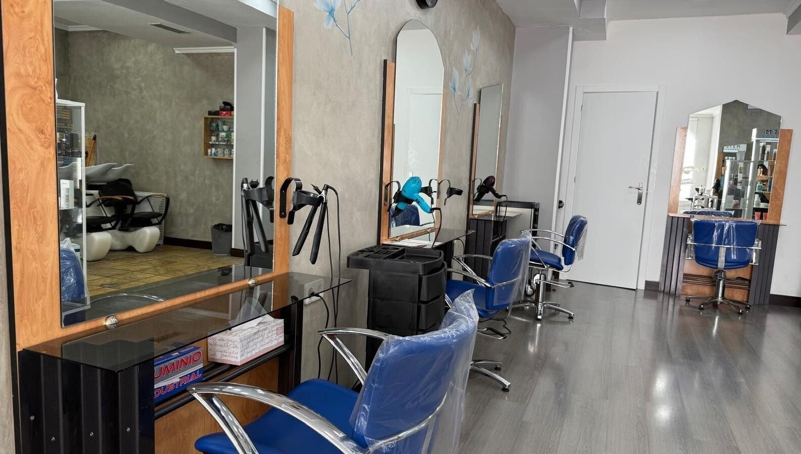 Vista interior de Karpe Peluquerías - Pozuelo en Pozuelo De Alarcón, Comunidad De Madrid, ES con modernos asientos azules.