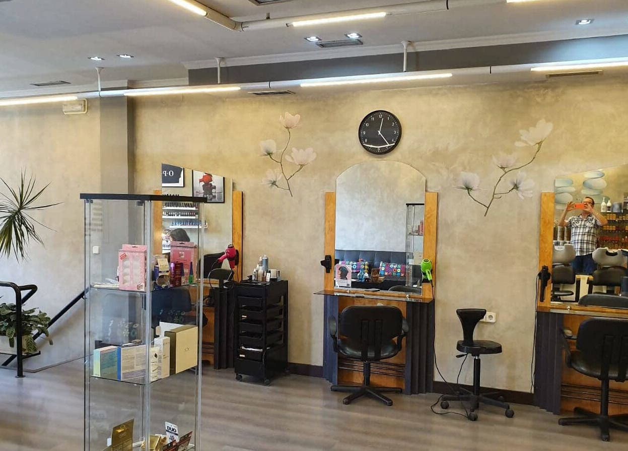 Interior de Karpe Peluquerías - Pozuelo, en Pozuelo De Alarcón, con estaciones de peluquería y decoración floral.