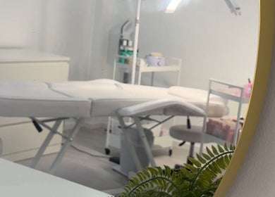Modern treatment room at Mimis Aesthetics in Shipley, England, GB with sleek white decor and green plant.