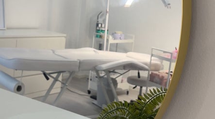 Modern treatment room at Mimis Aesthetics in Shipley, England, GB with sleek white decor and green plant.