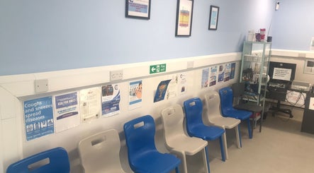 Seating area at GP Healthcare Alliance, Hadleigh, England, GB, showcasing modern chairs and health information.