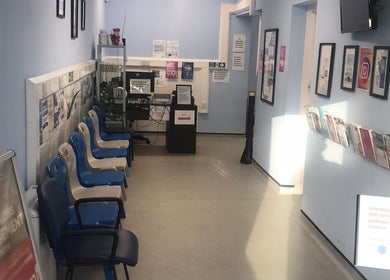 Bright waiting area at GP Healthcare Alliance, Hadleigh, England with chairs and informative wall displays.