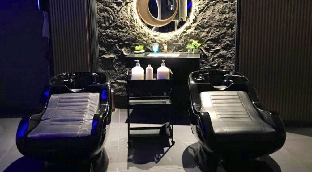 Luxurious shampoo stations at Salon Blue Shadow in عمّان, محافظة العاصمة, JO, with sleek black chairs.