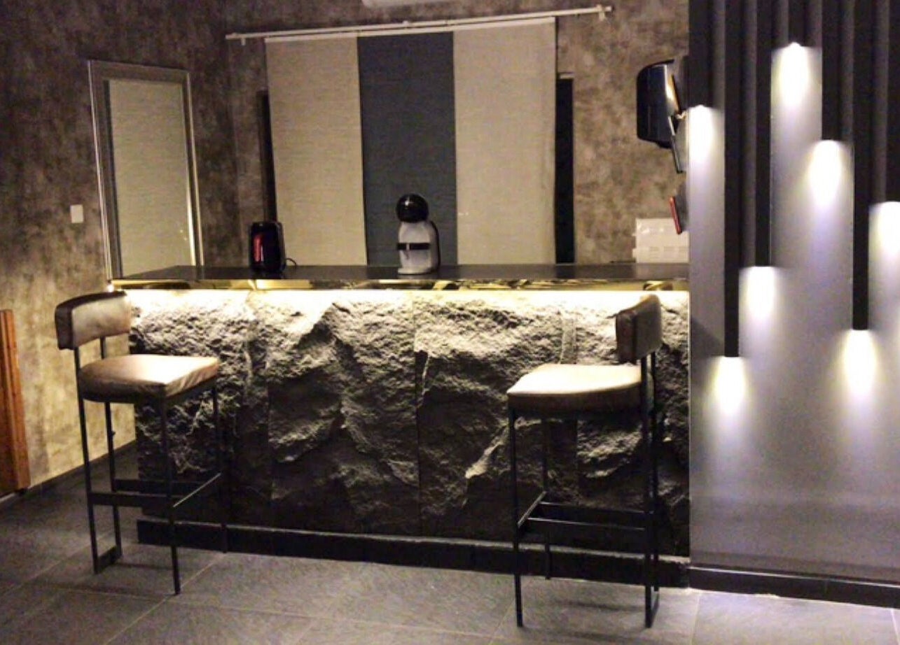 Chic bar area in Salon Blue Shadow with textured walls and stylish seating in عمّان, محافظة العاصمة, JO.