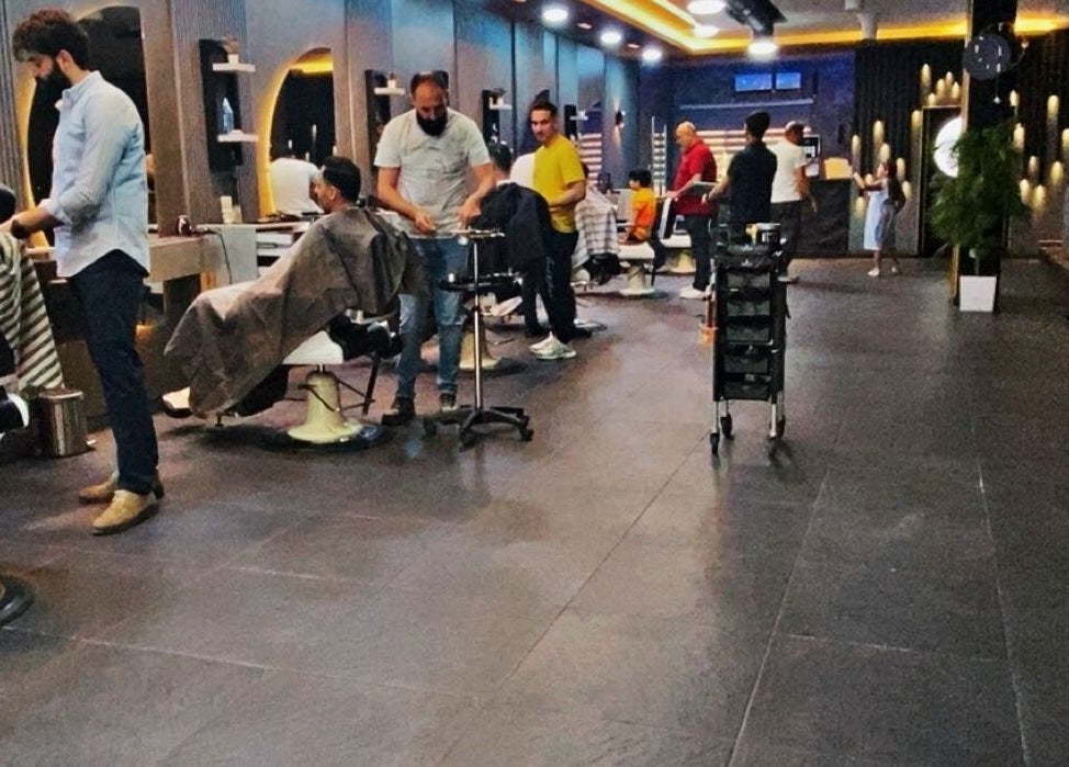 Clients receiving haircuts at Salon Blue Shadow, vibrant atmosphere in عمّان, محافظة العاصمة, JO.