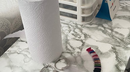 A neat marble countertop at Fefesnailboutique in Akasia, Gauteng, ZA with paper towels and nail polish samples.