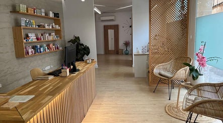 Recepción de Cos Naturalis en Alcúdia, Illes Balears, ES, con estanterías y sillas de mimbre.