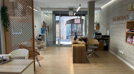 Recepción moderna en Cos Naturalis, Alcúdia, Illes Balears, ES, con muebles elegantes y ambiente cálido.