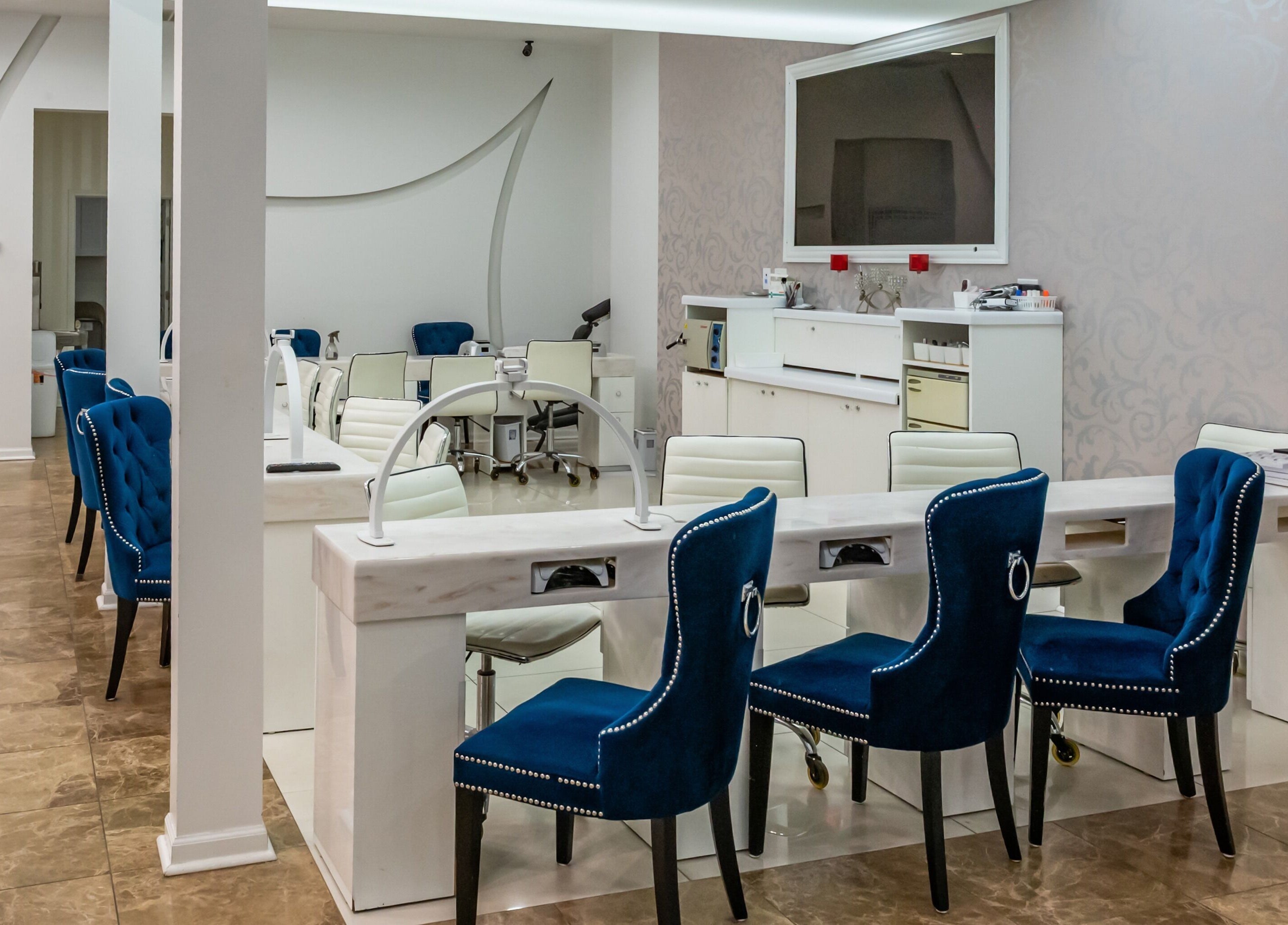 Couture Nails and Waxing offers a pristine manicure area in Chicago, Illinois, US with blue plush chairs.