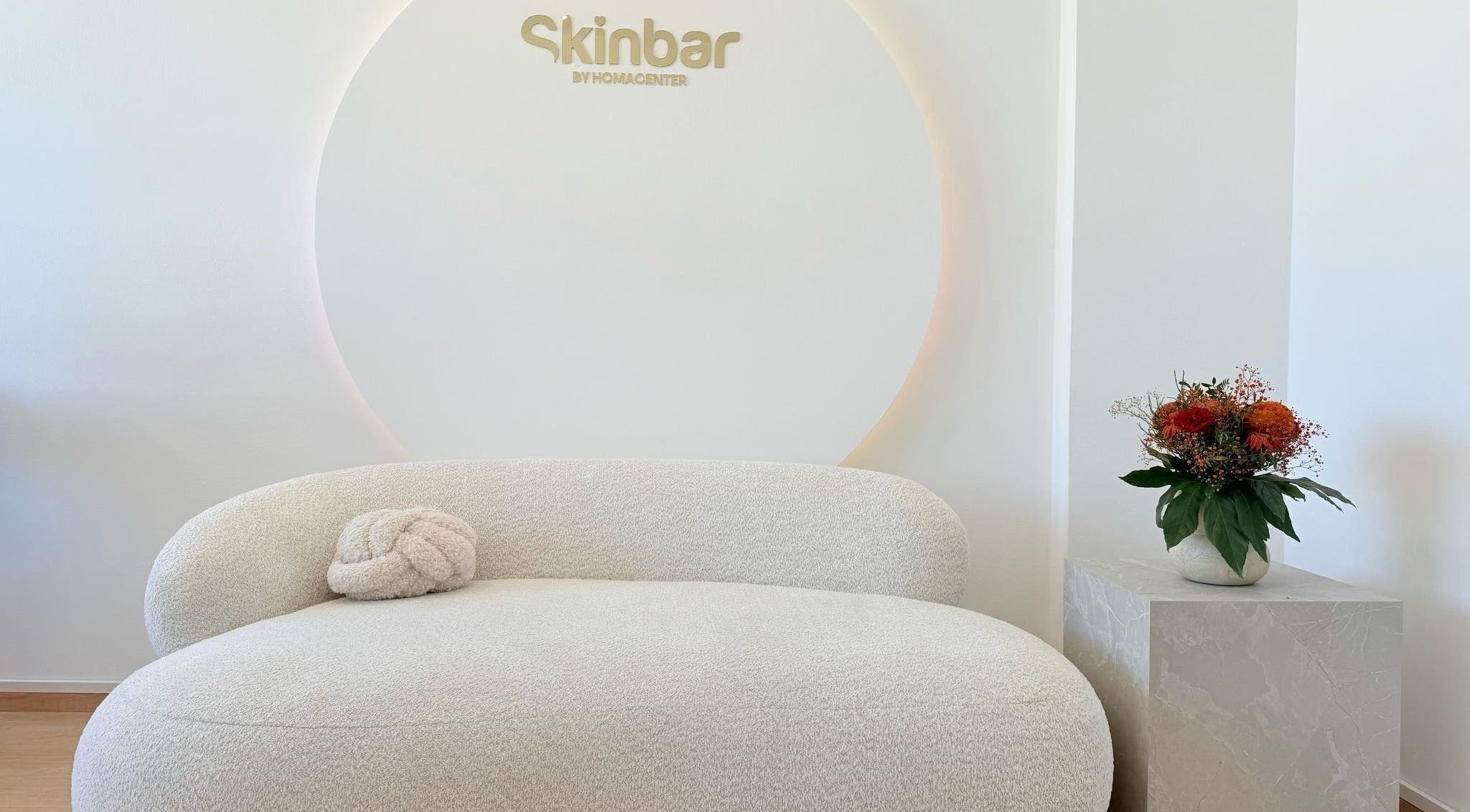 Eleganter Wartebereich bei Nailbar Wien, Wien, AT, mit bequemer weißer Couch und Blumendekor.