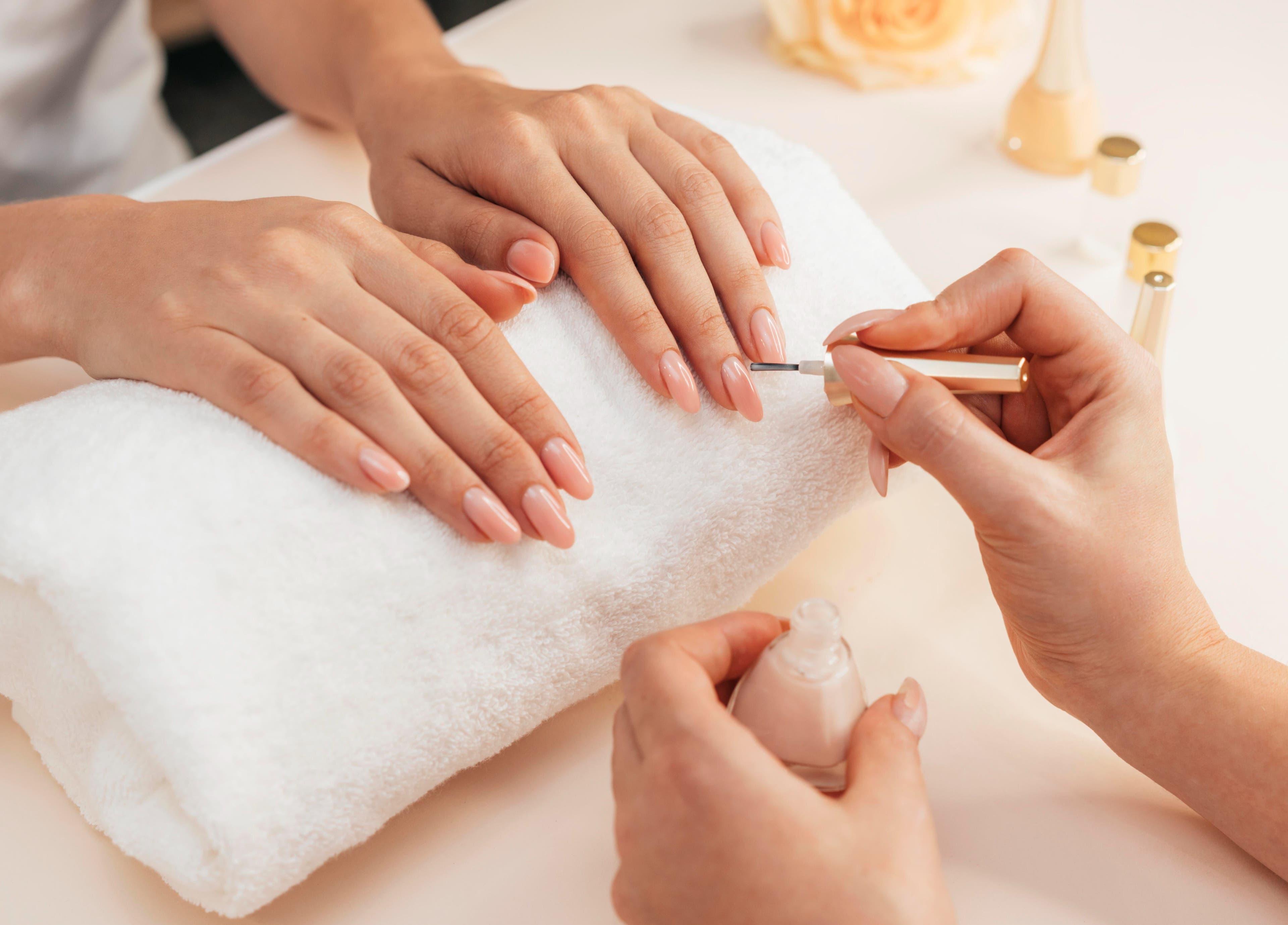 Maniküre bei Nailbar Wien, Wien, Wien, AT, zeigt gepflegte, lackierte Nägel auf weißem Handtuch.