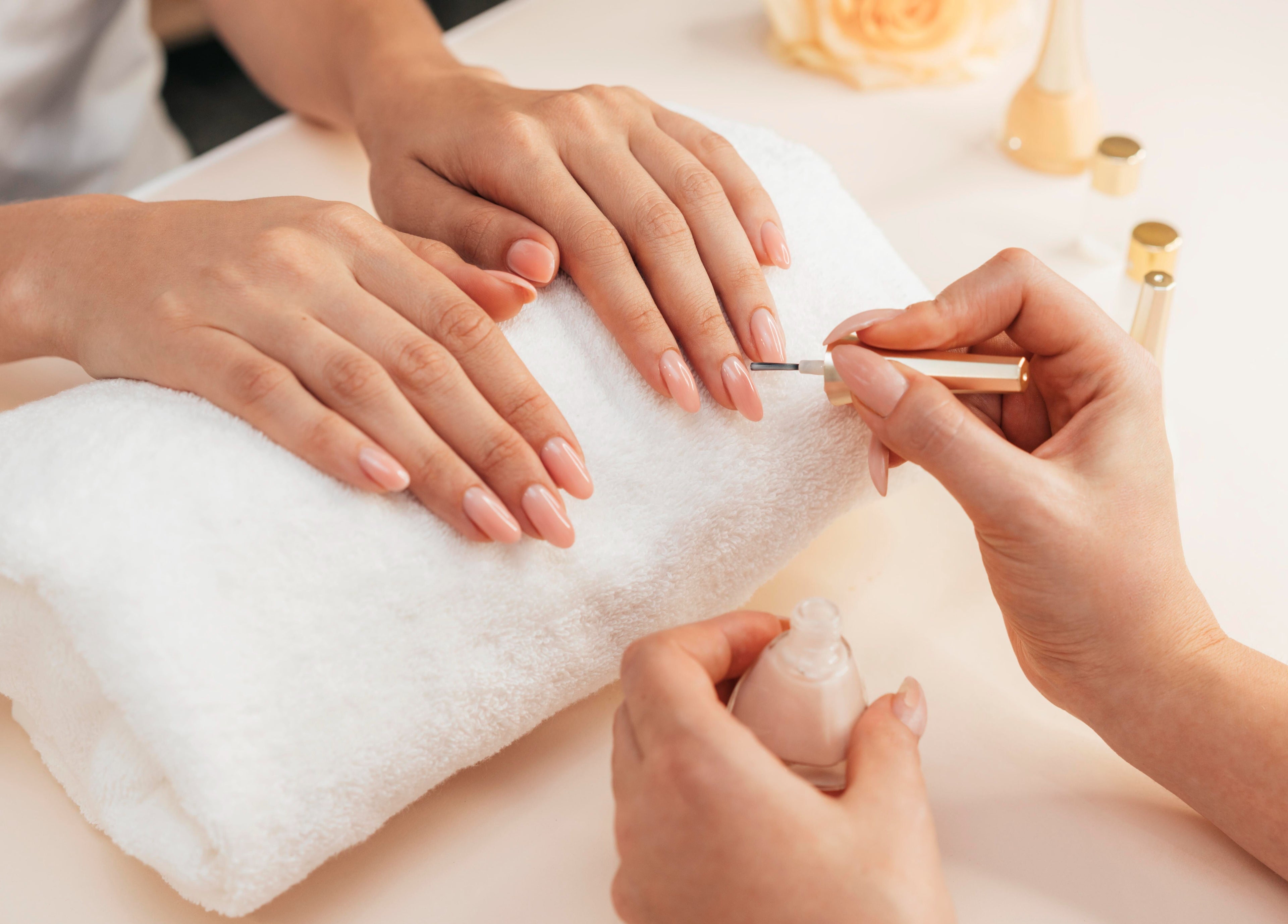 Maniküre bei Nailbar Wien, Wien, Wien, AT, zeigt gepflegte, lackierte Nägel auf weißem Handtuch.