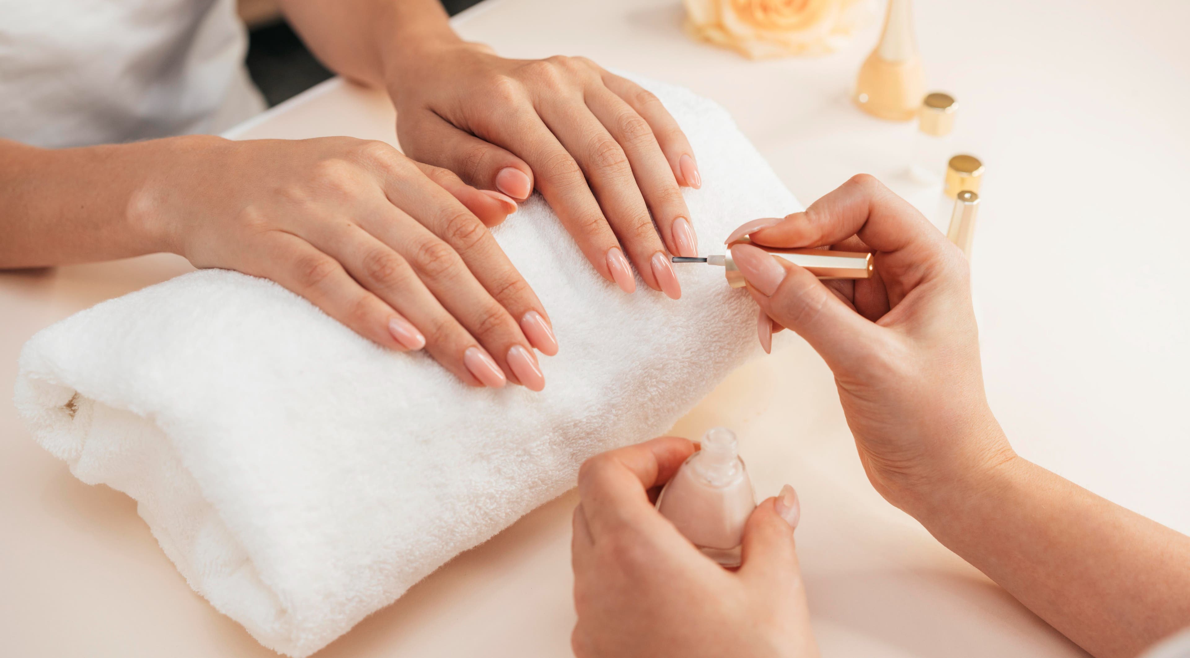 Maniküre bei Nailbar Wien, Wien, Wien, AT, zeigt gepflegte, lackierte Nägel auf weißem Handtuch.