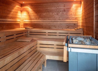 Relaxing sauna at Pullman Fit & Spa Lounge in Stuttgart, Baden-württemberg, DE, with wooden seating and heated stones.