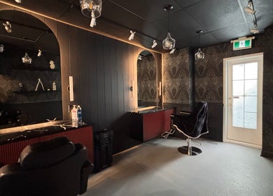 Chic interior of The Masque Atelier in Toronto, Ontario, CA with dark decor and styling chairs.