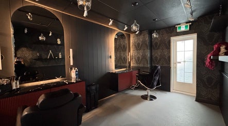 Chic interior of The Masque Atelier in Toronto, Ontario, CA with dark decor and styling chairs.