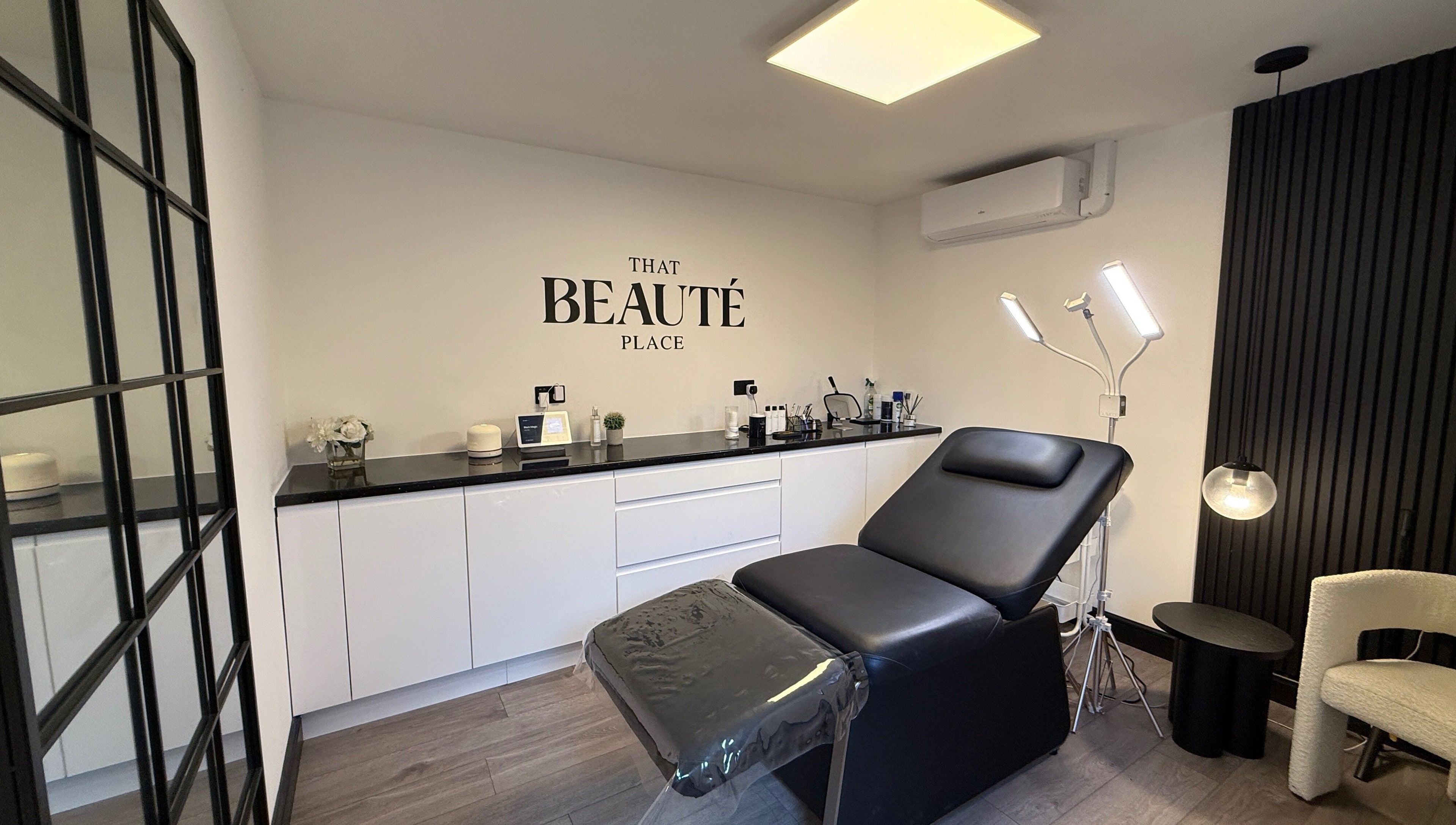 Chic treatment room at That Beaute Place, Alconbury, England, GB, featuring a modern black reclining chair.