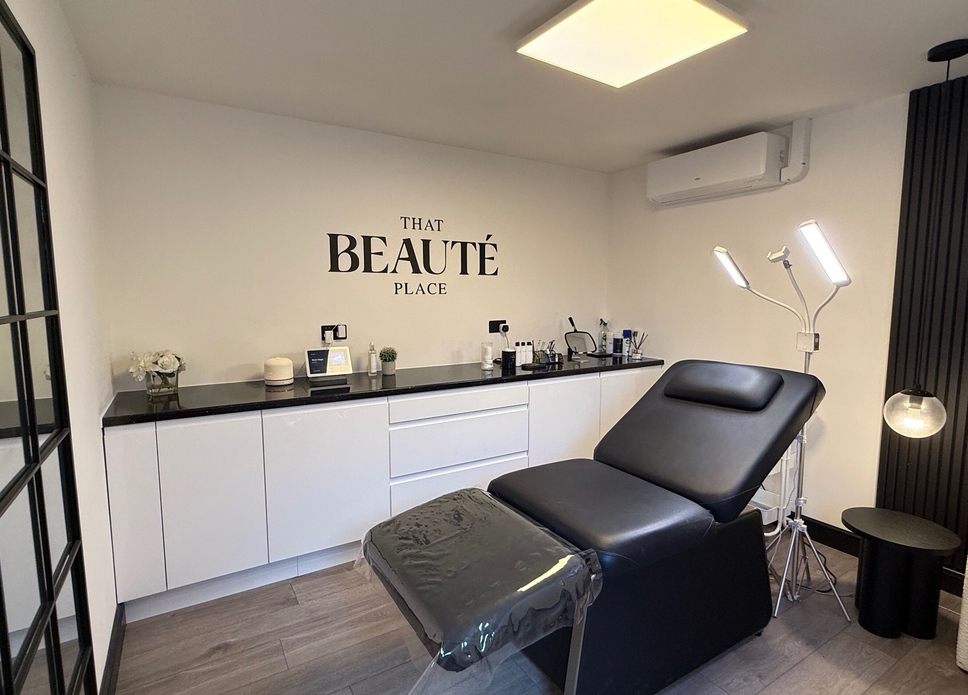 Chic treatment room at That Beaute Place, Alconbury, England, GB, featuring a modern black reclining chair.