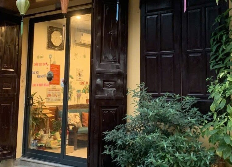 Mặt trước Senviet Spa Care, Hà Nội, Hà Nội, VN với cửa gỗ và cây xanh.