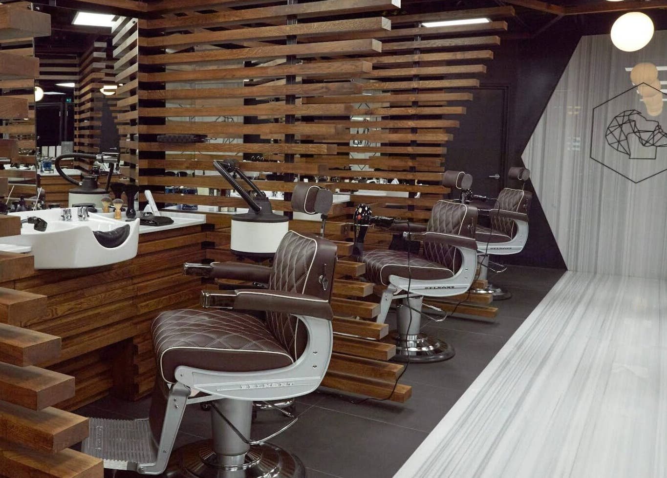 Interior of Adam Grooming Atelier - Brookfield Place in New York, New York, US. Sleek barber chairs with plush decor.