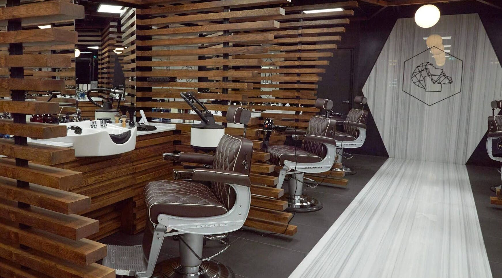 Interior of Adam Grooming Atelier - Brookfield Place in New York, New York, US. Sleek barber chairs with plush decor.