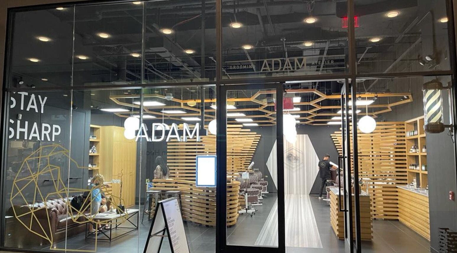Exterior view of Adam Grooming Atelier - Brookfield Place, New York, showcasing chic interior with grooming stations.