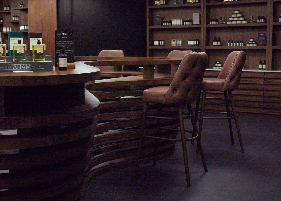Elegant interior of Adam Grooming Atelier - Brookfield Place, New York, New York, US with leather chairs.