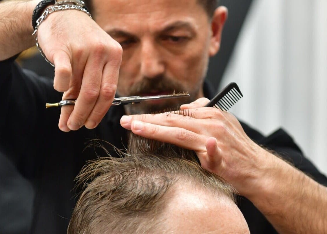 Stylist cutting hair at Adam Grooming Atelier - Brookfield Place, New York, New York, US.
