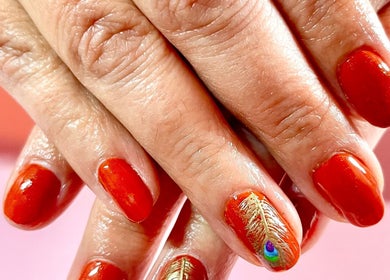 Vibrant red nails with peacock feather design at Nova Nails, Pontypridd, Wales, GB.