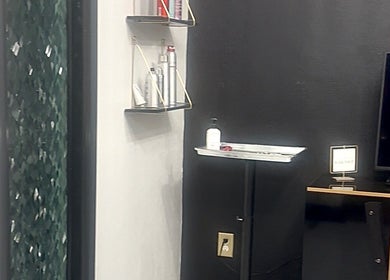 Modern salon corner at Mariah Savis Artistry, Mabank, Texas, US, featuring sleek black walls and beauty products.