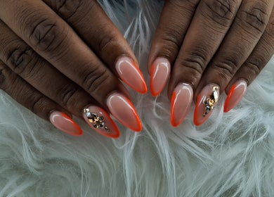Stylish orange-tipped nails with sparkling gems from Maestra of Divine Nail Art Inc. in Brighton, St. George, VC.