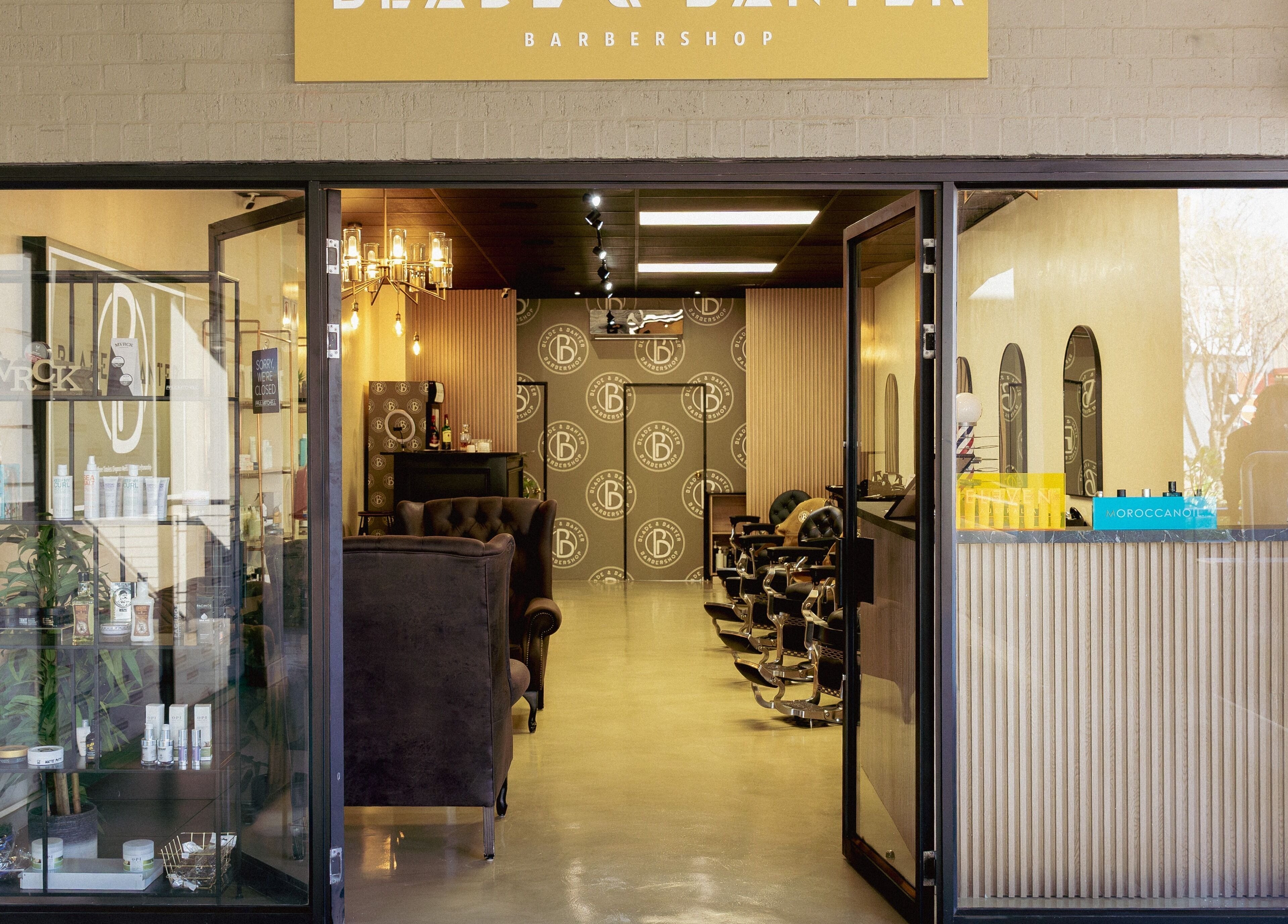 Entrance of Blade & Banter Barbershop in Midrand, Gauteng, ZA, showcasing stylish interior and barber chairs.